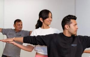 Group yoga class practicing warrior pose in indoor studio